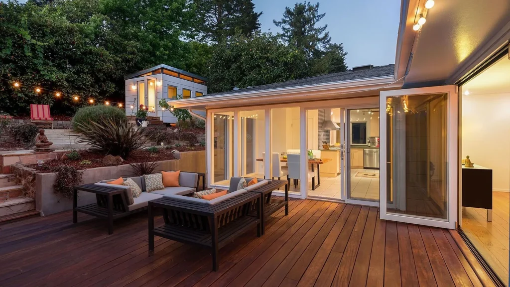 Outdoor deck with patio seating and string lights at dusk — W Rondon Construction