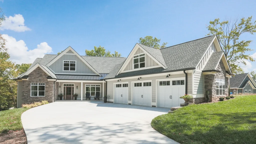 Craftsman-style home exterior with three-car garage and curved driveway — W Rondon Construction