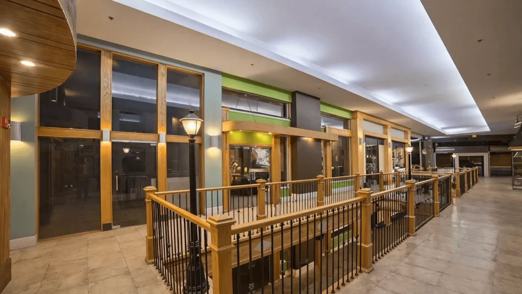 Interior corridor of a commercial retail space with wood railings and decorative lighting — W Rondon Construction