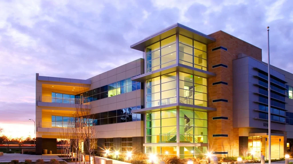 Multi-story commercial office building illuminated at dusk — W Rondon Construction